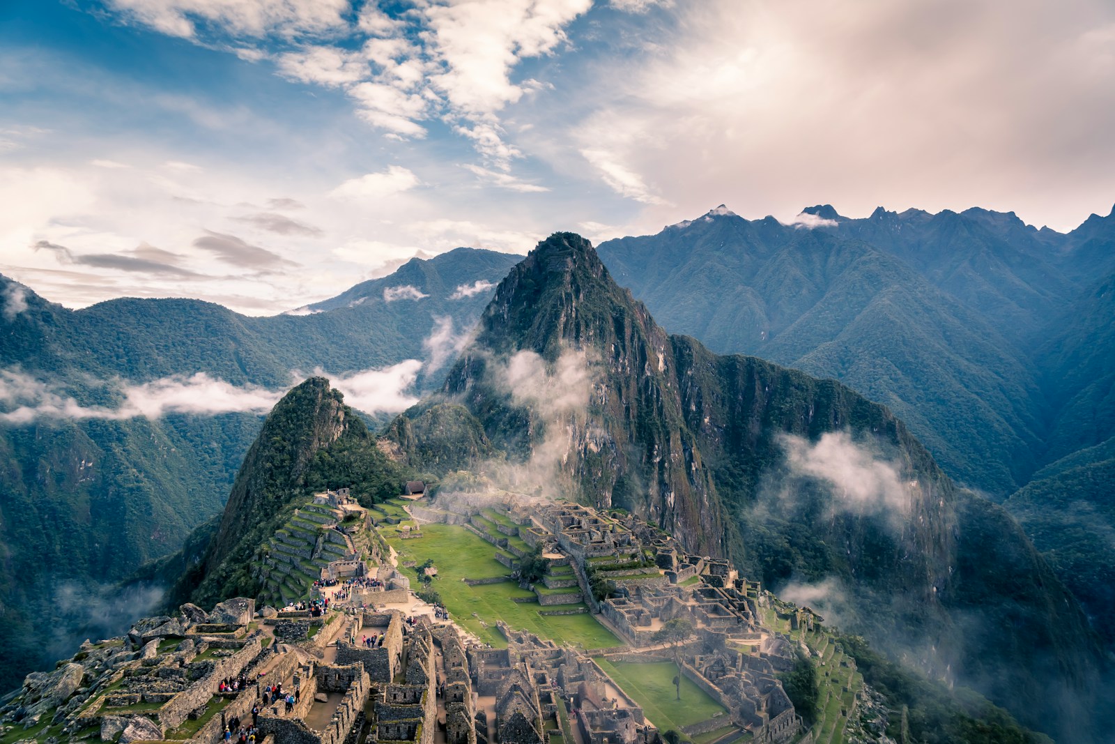 A couple in traditional ponchos admire the breathtaking view of Machu Picchu in Peru.