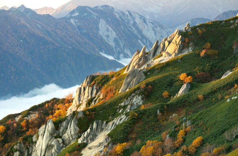 Jagged mountain ridge with autumn foliage and clouds